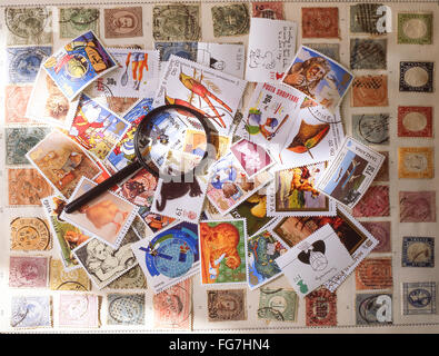 Collection de timbres avec loupe dans Studio, Berkshire, Angleterre, Royaume-Uni Banque D'Images