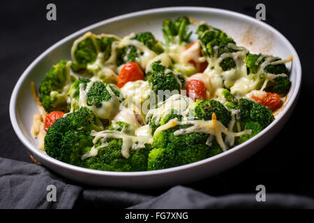 Le brocoli, tomate et fromage en cocotte à plat rond. Close up, selective focus Banque D'Images