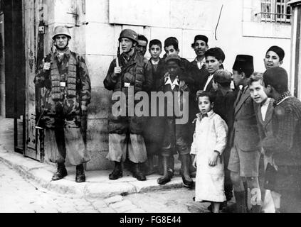 Le tableau de la propagande nazie montre des enfants locaux à côté des parachutistes de la Wehrmacht allemande dans la ville occupée de Tunis en Tunisie. La photo a été prise en février 1943. Fotoarchiv für Zeitgeschichtee - PAS DE SERVICE DE VIREMENT - Banque D'Images