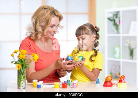 Mère et son enfant peindre des oeufs de pâques Banque D'Images