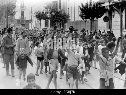 Le tableau de la propagande nazie montre des enfants locaux qui saluent les nazis lors d'une marche de soldats allemands dans la ville occupée de Tunis, Tunisie, février 1943. Fotoarchiv für Zeitgeschichtee - PAS DE SERVICE DE VIREMENT - Banque D'Images