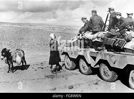 La photo de propagande nazie montre un local tunisien et des soldats de la Wehrmacht allemande sur un Panzerspähwagen (véhicule de reconnaissance blindé léger allumé) pendant la campagne tunisienne. La photo a été publiée en décembre 1942. Fotoarchiv für Zeitgeschichte - PAS DE SERVICE DE VIREMENT - Banque D'Images