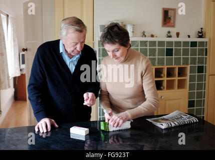 Couple de retraités âgés contrôle masculins et féminins sur pharmacien prescription comprimés en santé cuisine Banque D'Images