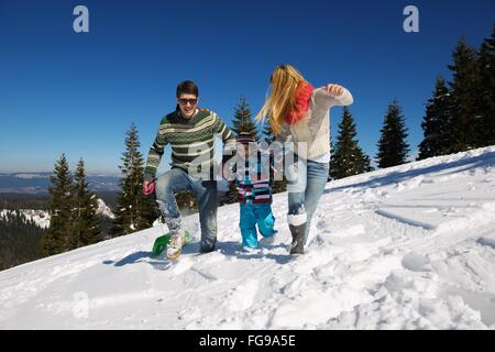 Family having fun sur la neige fraîche au winter Banque D'Images