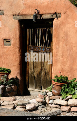 Une vieille porte en bois est placé dans un mur d'adobe dans le Canyon Road Arts District, Santa Fe, Nouveau Mexique. Banque D'Images