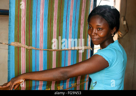 Femme africaine tisse sur métier à tisser traditionnel au Bénin. Banque D'Images