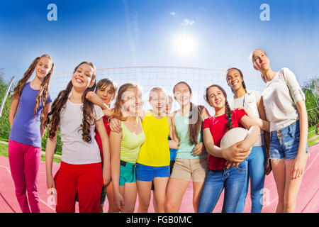 Les adolescents se tenir en face de filet de volley-ball, balle hold Banque D'Images