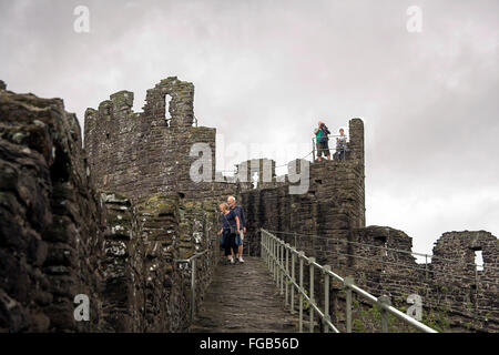 Les touristes visiter la cité fortifiée de murs en pierre, murs de la ville de Conwy, au nord du Pays de Galles, Royaume-Uni Banque D'Images