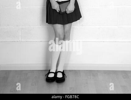Les jambes d'une jeune fille en uniforme d'organiser un ordinateur tablette générique. 9 Février 2016 Banque D'Images