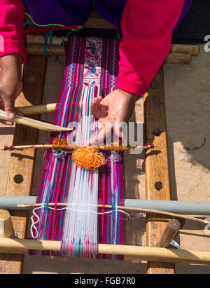 Femme à l'aide à tisser traditionnel pour tisser un chiffon. Banque D'Images