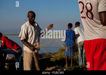 Pêcheur réparer leurs filets de pêche sur les rives du lac de l'Afrique Ethiopie Hawassa Banque D'Images