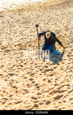 L'homme à l'aide de détecteur de métal sur sandy à Swanage Banque D'Images