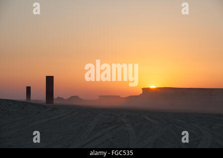 Coucher de soleil sur l'Ouest Est Ouest à l'Est dans le désert qatari. Installation d'art public par Richard Serra commandé par le Qatar Museums Authority. Banque D'Images