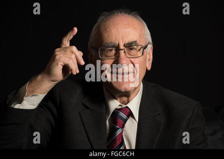 Plus d'affaires, portant des lunettes sur fond noir pointant avec son doigt Banque D'Images