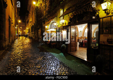 Restaurant dans une étroite rue pavée, à Rome, Italie Banque D'Images