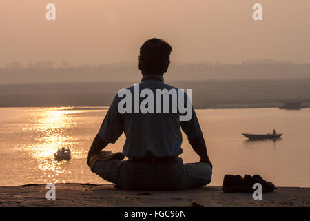 Méditer, méditation/yoga / Méditation au lever du soleil sur la rivière à Ganges. La culture de Varanasi est étroitement associée à la rivière Banque D'Images