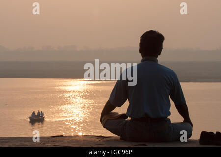 Méditer, méditation/yoga / Méditation au lever du soleil sur la rivière à Ganges. La culture de Varanasi est étroitement associée à la rivière Banque D'Images