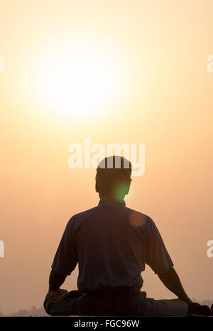 Méditer, méditation/yoga / Méditation au lever du soleil sur la rivière à Ganges. La culture de Varanasi est étroitement associée à la rivière Banque D'Images