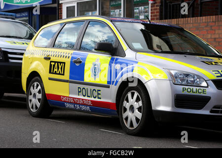 Voiture de police dans le centre-ville de Worthing moitié peint comme un taxi pour promouvoir un don't drink and drive campagne. Banque D'Images