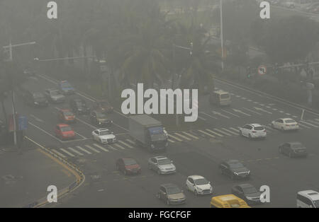 Haikou, province de Hainan en Chine. Feb 19, 2016. Véhicules roulent dans un épais brouillard à Haikou, capitale de la province de Hainan en Chine du sud, le 19 février, 2016. Crédit : Yang Guanyu/Xinhua/Alamy Live News Banque D'Images