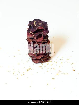 Une pile de chips de betterave ronde fine cuit au four avec l'origan et le sel empilées sur fond blanc. Un sain, végétarien, v Banque D'Images