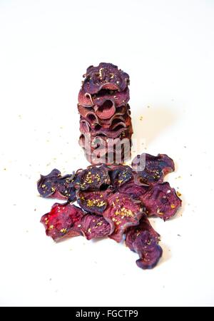 Une pile de chips de betterave ronde fine cuit au four avec l'origan et le sel empilées sur fond blanc. Un sain, végétarien, v Banque D'Images