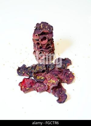 Une pile de chips de betterave ronde fine cuit au four avec l'origan et le sel empilées sur fond blanc. Un sain, végétarien, v Banque D'Images