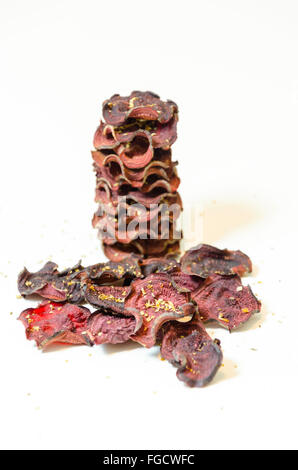 Une pile de chips de betterave ronde fine cuit au four avec l'origan et le sel empilées sur fond blanc. Un sain, végétarien, v Banque D'Images