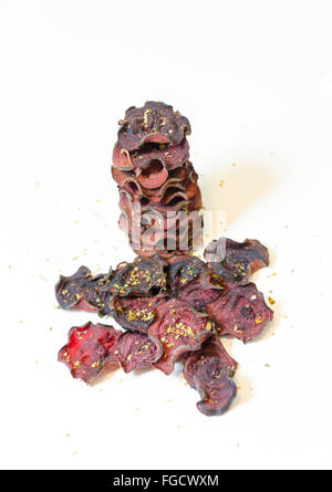 Une pile de chips de betterave ronde fine cuit au four avec l'origan et le sel empilées sur fond blanc. Un sain, végétarien, v Banque D'Images