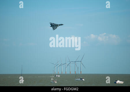 Sur la mer à Clacton-on-sea, montrant de petits bateaux et les éoliennes comme un Vulcain avion vole au-dessus. Banque D'Images