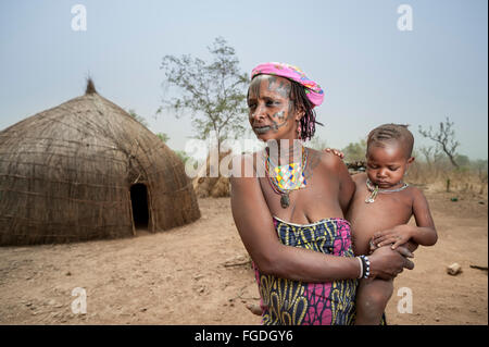 Portrait d'une femme Mbororo dans un cas typique d'une scarification sur son visage tenant son enfant. Banque D'Images