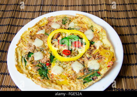 Un épinards, menthe, piment et poivre omelette dans un plat sur le bambou table cloth. Un régime alimentaire sain repas Omelette. Banque D'Images