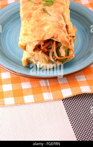 Burrito avec tomates et fromage sur la plaque bleue Banque D'Images