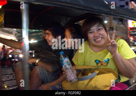 Les touristes asiatiques à l'intérieur d'un Tuk Tuks taxi dans la rue. Vue vers le bas Thanon Yaowarat Road dans la nuit dans le centre de Chinatown District de Ba Banque D'Images