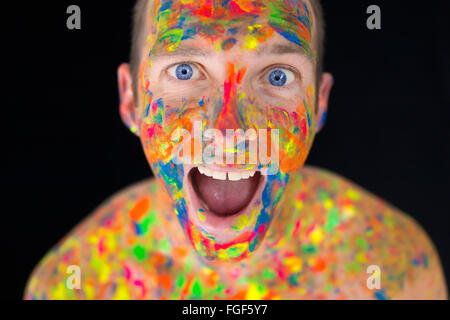 Close up of a man's face recouverte de peinture multicolores Banque D'Images