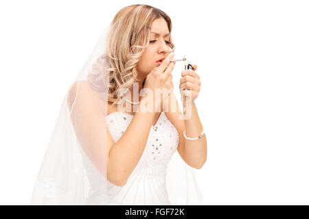 Jeune mariée nerveux d'allumer une cigarette isolé sur fond blanc Banque D'Images