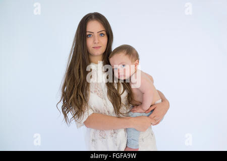 Mother holding baby boy smiling in arms Banque D'Images