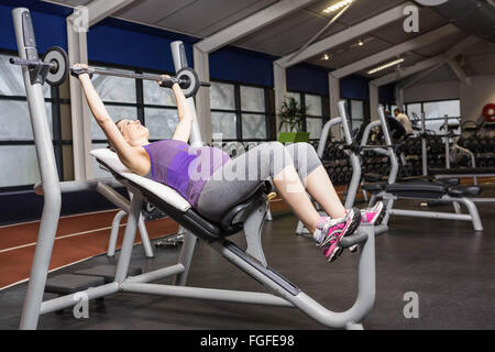 Smiling pregnant woman lifting barbell Banque D'Images