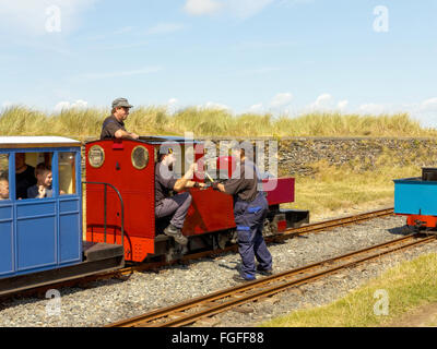 Deux pilotes d'un moteur à vapeur à voie étroite de chemin de fer mer échanger des jetons d'assurer la sécurité pour la prochaine section de voie. Banque D'Images