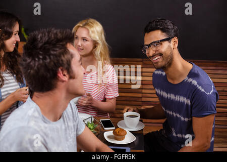 Smiling friends enjoying coffee together Banque D'Images