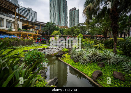 Jardins et de gratte-ciel au parc de Greenbelt, dans Ayala, Makati, Metro Manila, Philippines. Banque D'Images