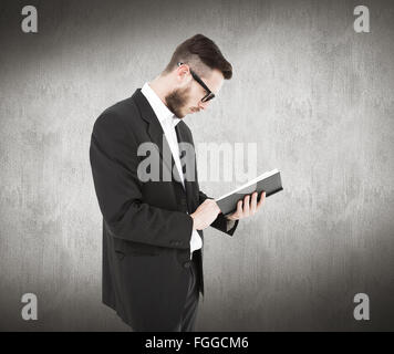 Image composite de geeky jeune homme de la lecture du livre noir Banque D'Images