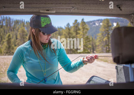 Une femme avant de la tige de forage sa mouche Montana's Gallatin River. Banque D'Images