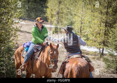 Wrangler et invité sur des chevaux à un Montana guest ranch. Banque D'Images