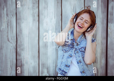 Smiling hipster femme écouter de la musique forte à travers des écouteurs Banque D'Images