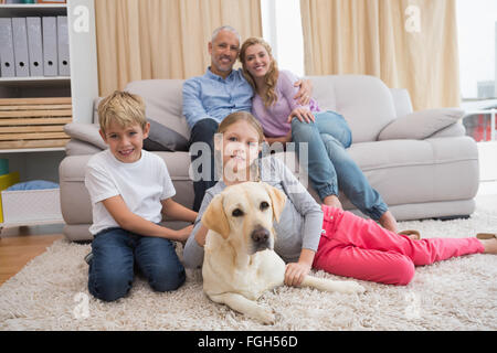 Les parents et leurs enfants sur le canapé avec le labrador Banque D'Images