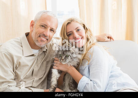 Couple heureux avec chat sur canapé Banque D'Images
