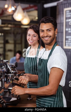 Smiling baristas en utilisant machine à café Banque D'Images