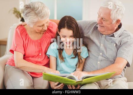 Les grands-parents de lire un livre avec sa petite-fille Banque D'Images
