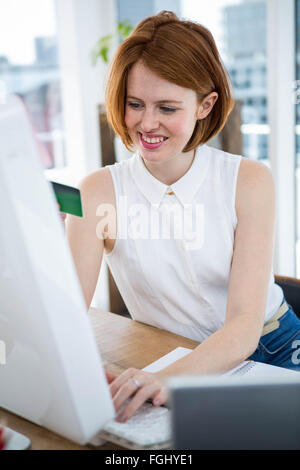 Hipster smiling business woman la saisie de son numéro de carte de crédit Banque D'Images